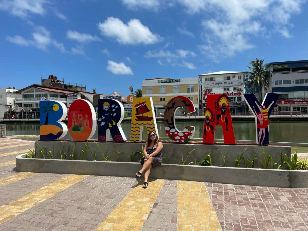 Une femme posant devant les lettres B O R A C A Y