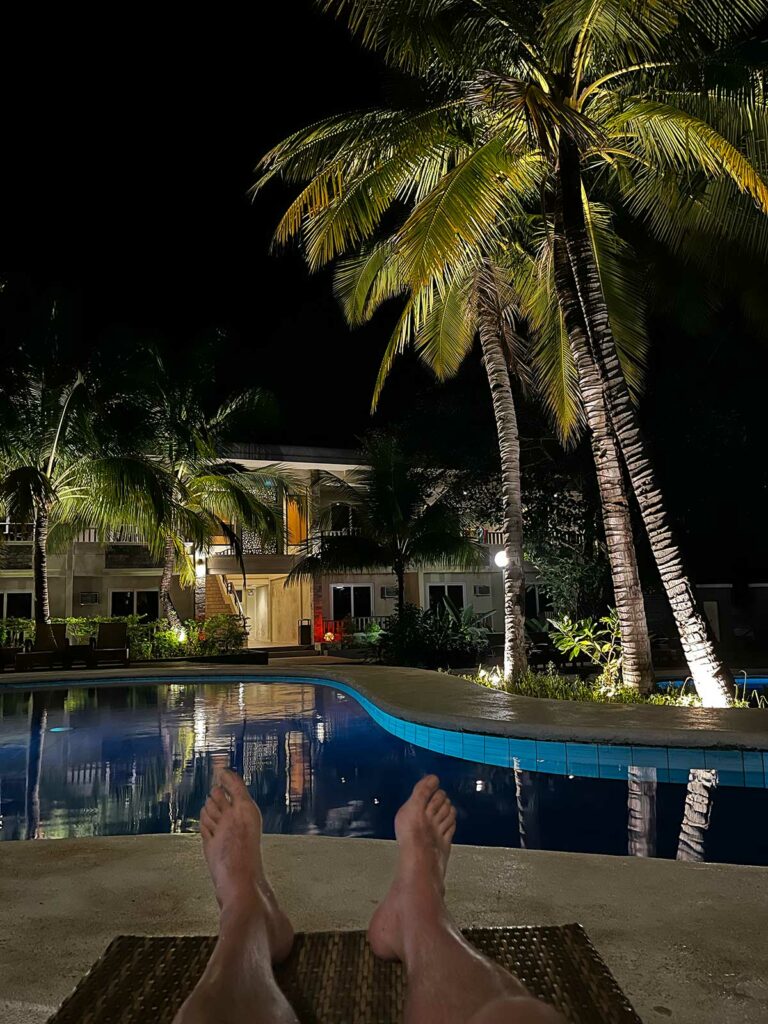 MO2 Lagoon Coron Hôtel : Les pieds d'un homme au bord de la piscine
