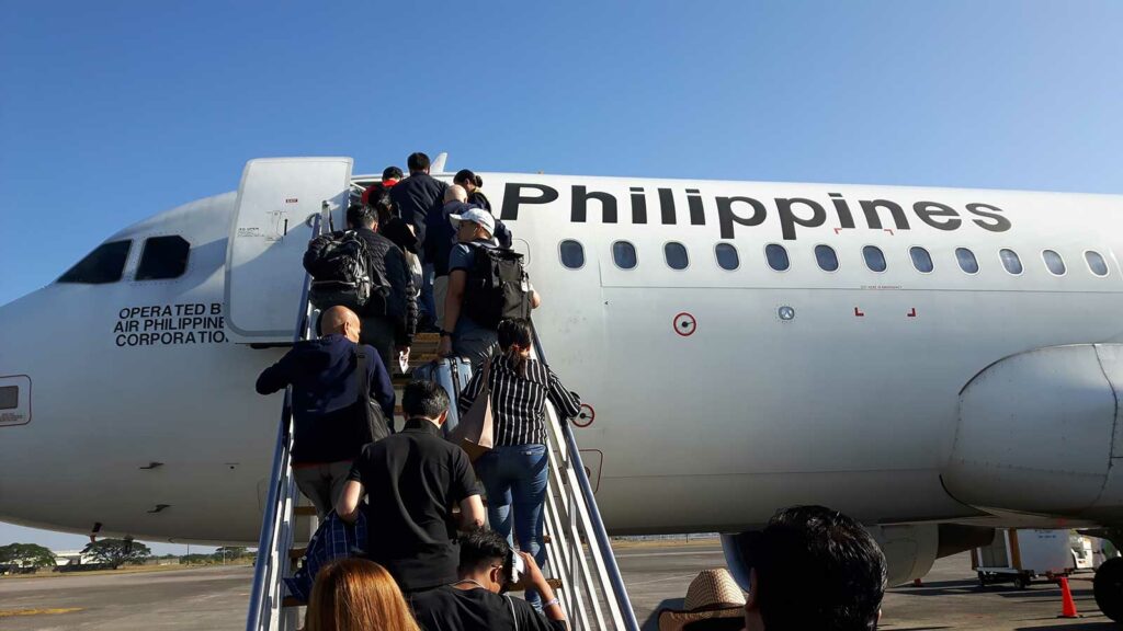 combien de temps pour aller aux philippines : des gens qui montent dans un avion