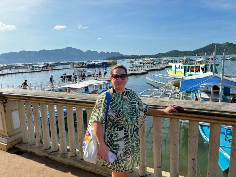 Une femme posant devant le port avant un island hopping coron