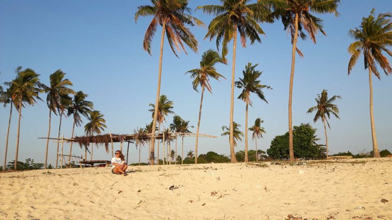 quand partir aux philippines : une femme assise sur la plage