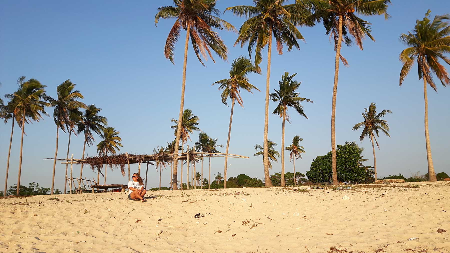 quand partir aux philippines : une femme assise sur la plage