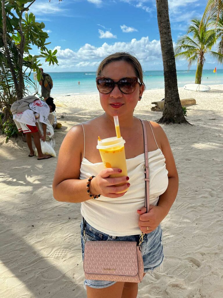 Visiter Boracay : une femme qui boit un jus sur la plage