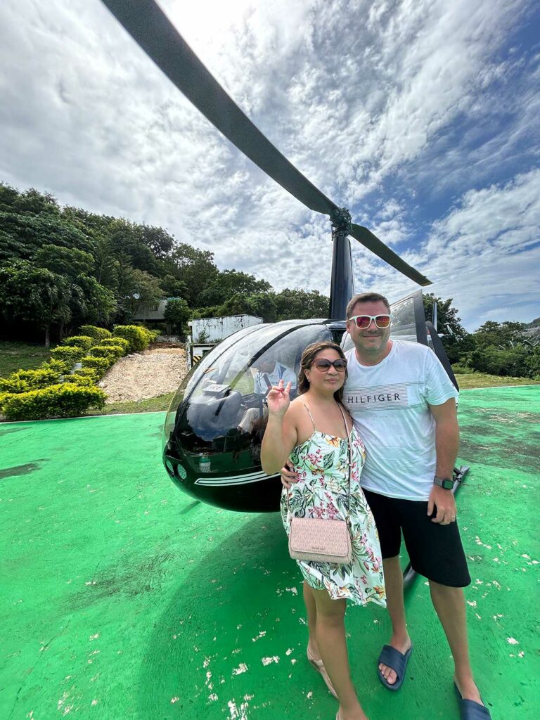 Un couple posant devant un hélicoptère