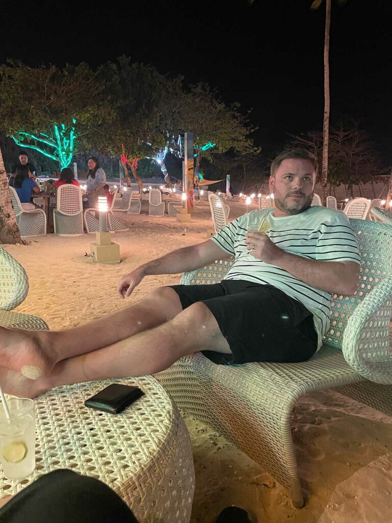 Un homme buvant un verre sur la plage