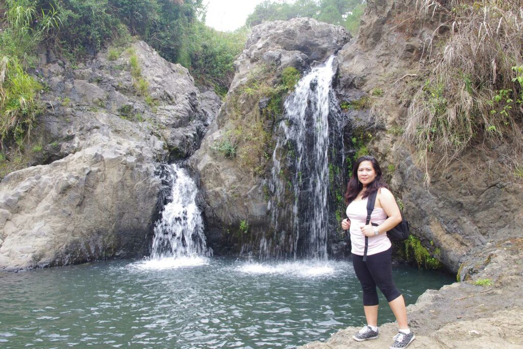 Une femme devant une cascade à Sagada aux Philippines
