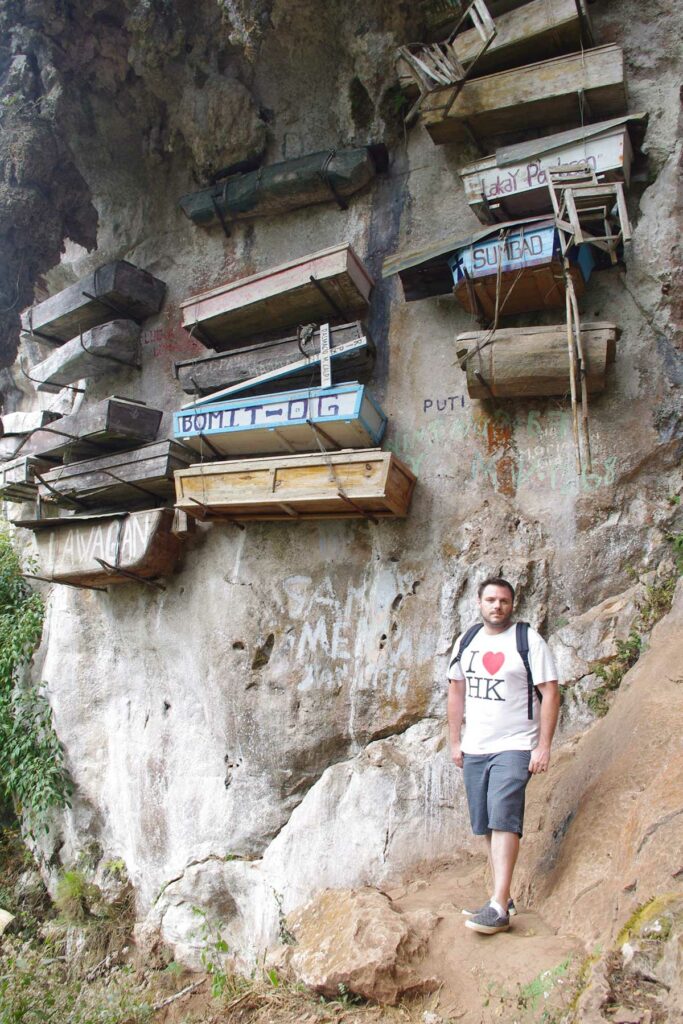 Un homme devant les cercueils à Sagada aux Philippines